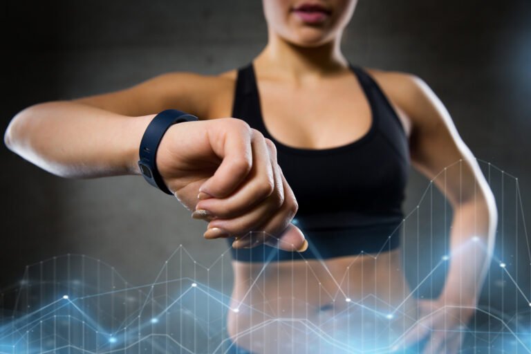 “Personal trainer using fitness tracker data to guide a client’s progress.”